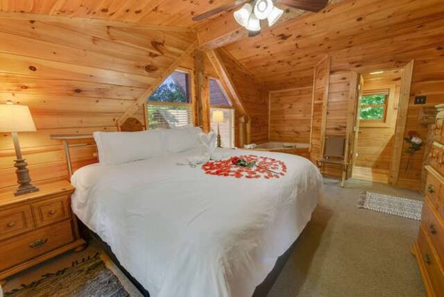 cabin bedroom with rose peddles in shape of heart on bed