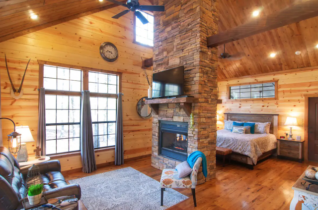 studio honeymoon cabin with fireplace separating living room from bedroom area